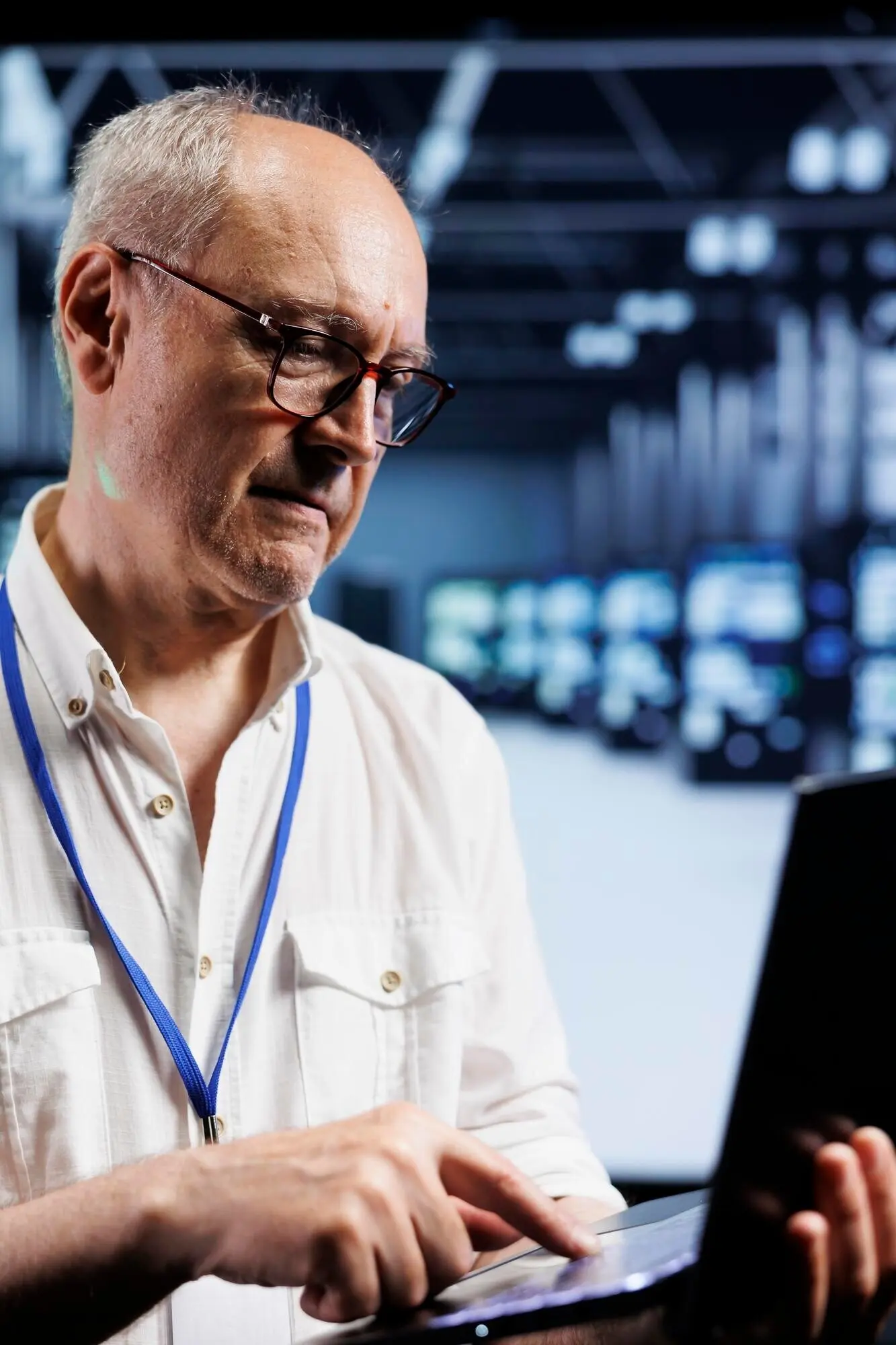 Ein Informatiker inspiziert Supercomputer in einem Rechenzentrum und stellt einen reibungslosen Betrieb sicher. Ein fachkundiger Spezialist überwacht im Serverraum mit einem Laptop den Energieverbrauch über Einheiten und Komponenten.