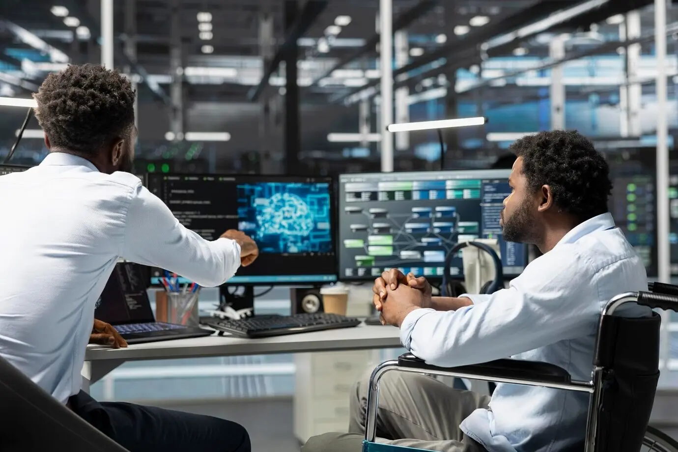 Ein Serverraumleiter und ein Mitarbeiter im Rollstuhl verwenden künstliche Intelligenz.